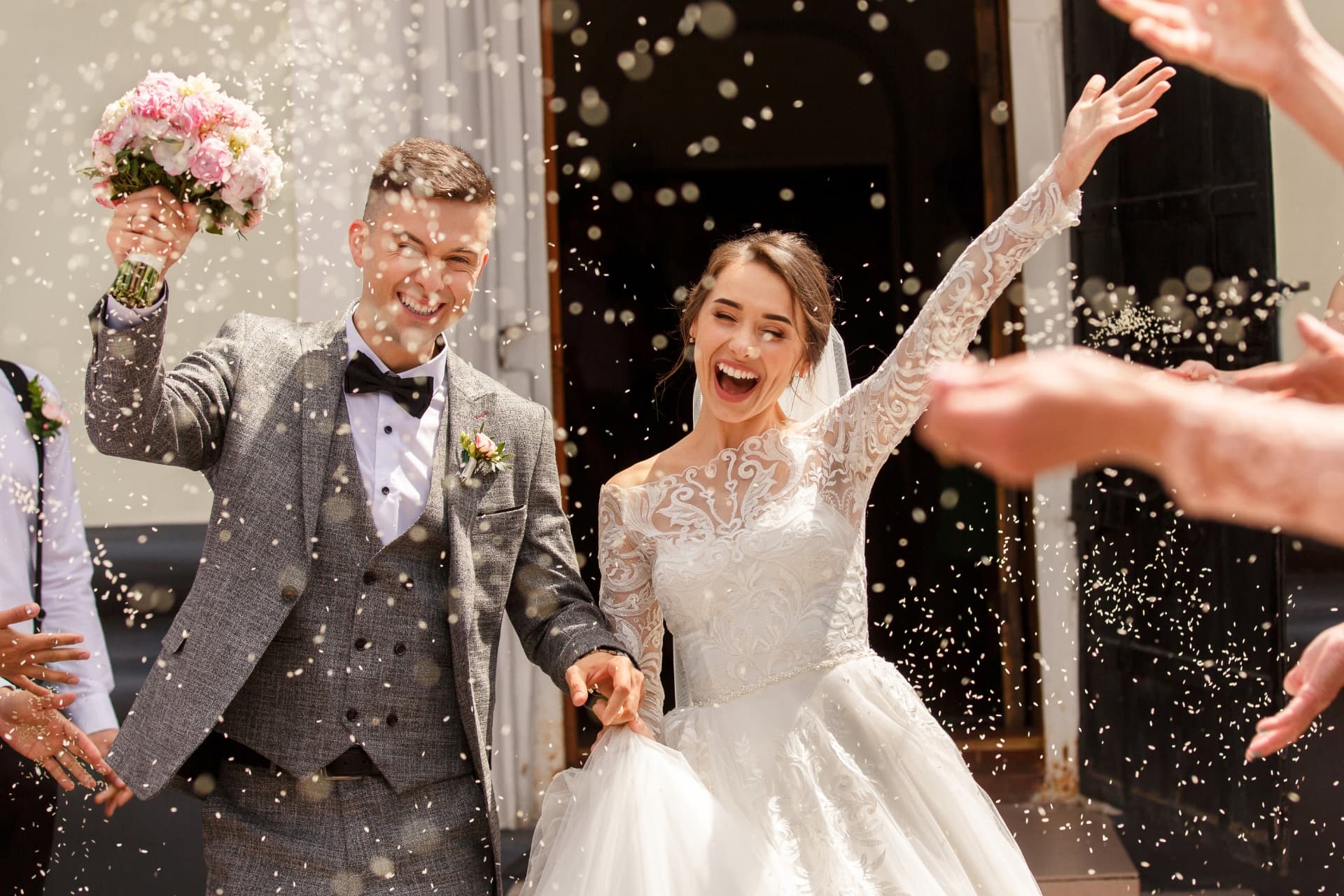 A newly married couple celebrating outside with confetti